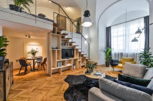 una gran sala de estar con una escalera y una mesa en Lazenska N4 Residence, en Praga