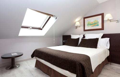 a bedroom with a large bed with a window at Hotel San Juan de los Reyes in Toledo