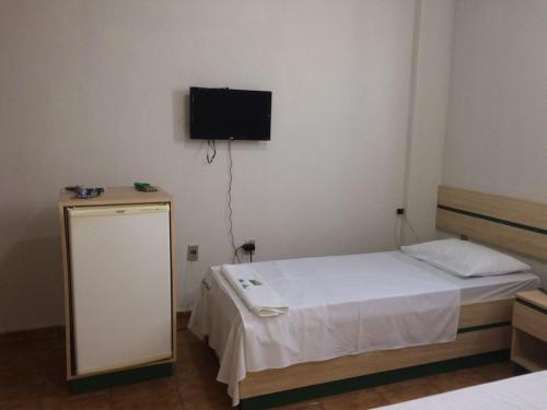 a bedroom with a bed and a television on the wall at Hotel Real in Petrolina