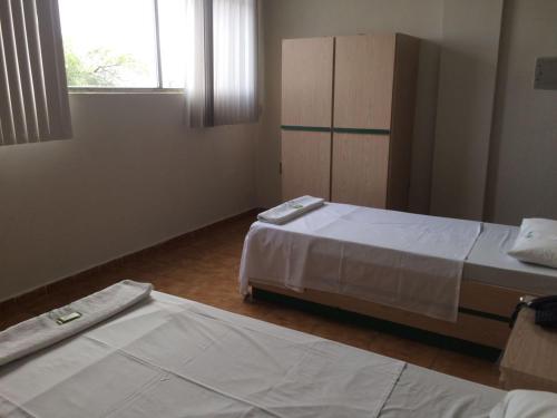 a bedroom with two beds and a window at Hotel Real in Petrolina