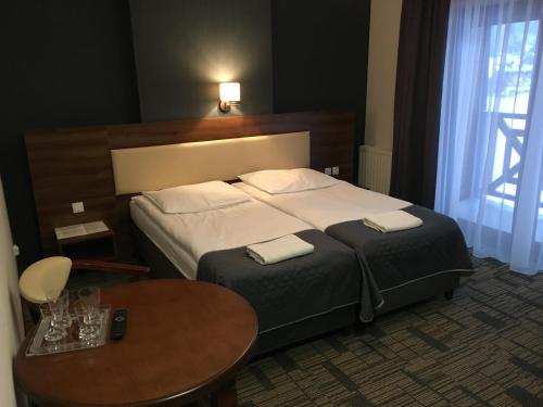 a hotel room with a bed and a table at Centrum Promocji Leśnictwa w Mucznem in Lutowiska