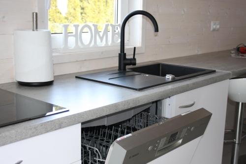 a kitchen with a sink and a dishwasher at Azalia 32 Mielno l in Mielno