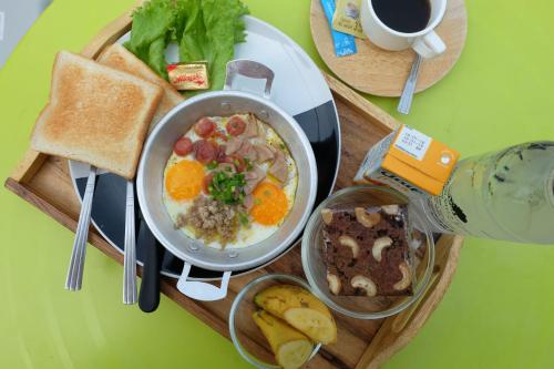 een dienblad met een kom ontbijt en toast bij Maerim Villa&Pool in Mae Rim