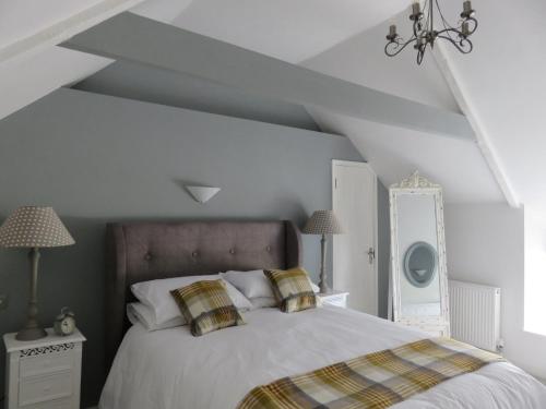 a bedroom with a large white bed with pillows at The Golden Mile Country Inn in Ewenny