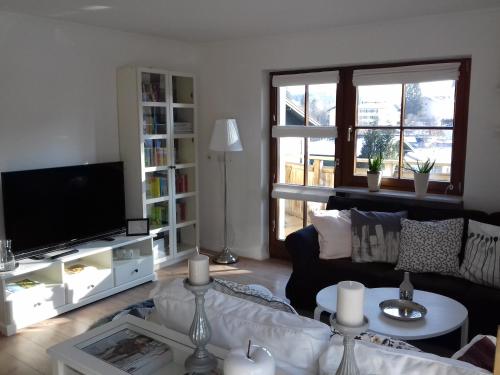 a living room with a couch and a tv at Ferienwohnung Wiesmühlstrasse in Henndorf am Wallersee