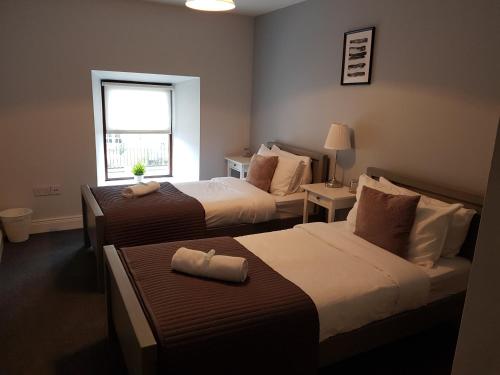 a hotel room with two beds and a window at The Enniskerry Inn in Enniskerry