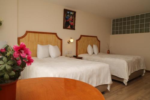 a hotel room with two beds and a table at Sol Plaza Hotel in Puno