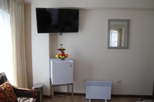 a living room with a tv on a white wall at Sol Plaza Hotel in Puno