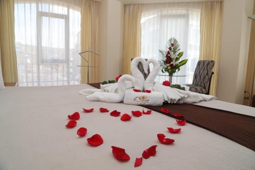 a bed with red rose petals forming a heart at Sol Plaza Hotel in Puno