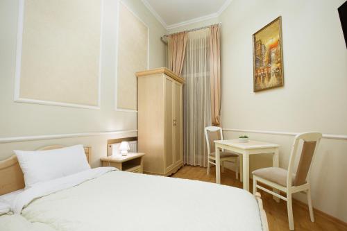 a bedroom with a bed and two chairs and a table at Apartment on Sumskaya 46 "Central Residence" in Kharkiv
