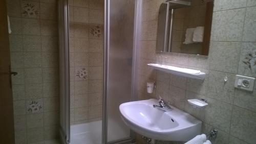 La salle de bains est pourvue d'un lavabo et d'une douche. dans l'établissement Garni Mühlanger, à Tirolo