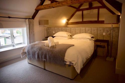 a bedroom with a bed with white sheets and a window at The Greenman Fownhope Hereford in Fownhope