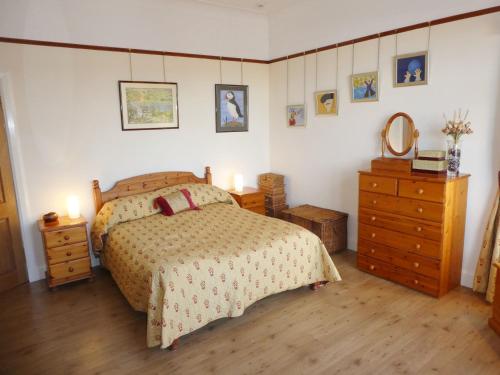 a bedroom with a bed and a dresser at The Cairn Residence in Edinburgh