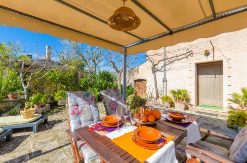 a table and chairs under an umbrella on a patio at Sabor De Cas Ferrer in Montuiri