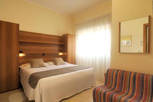 - une chambre avec un grand lit et une fenêtre dans l'établissement Albergo Anita Alassio, à Alassio