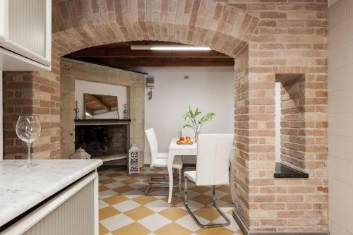 a kitchen with a brick archway with a table and chairs at B&B San Giacomo in Cagliari