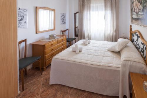 a bedroom with a large white bed and a dresser at Niza in Gandía