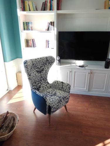 a chair in front of a tv in a living room at Olive Tree in Tirana