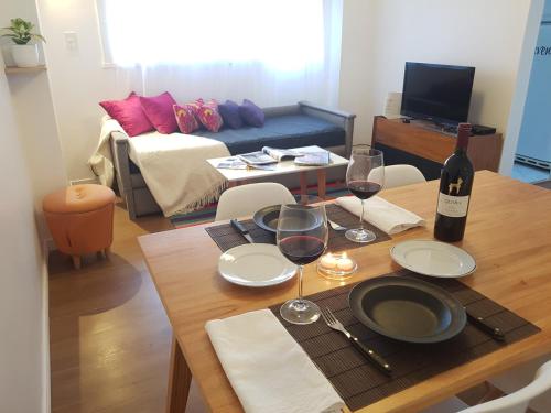 Zimmer mit einem Tisch mit Weingläsern und einem Bett in der Unterkunft Pisos Baires 3 in Buenos Aires