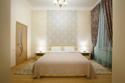 a bedroom with a bed with two nightstands and two lamps at Apartment on Sumskaya 46 "Central Residence" in Kharkiv