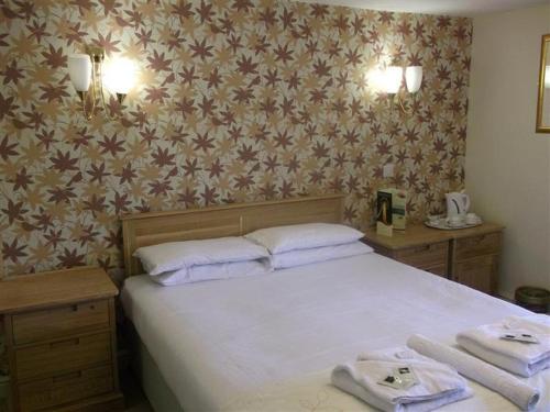 a bedroom with a bed with two towels on it at Radstock Hotel near Bath in Radstock