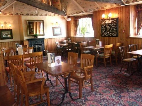 a restaurant with tables and chairs and a fireplace at Radstock Hotel near Bath in Radstock