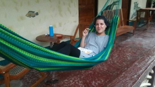 a man is sitting in a hammock at Zazil Ha Hostel in El Remate