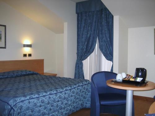a hotel room with a bed and a table and a window at Hotel Brandoli in Verona