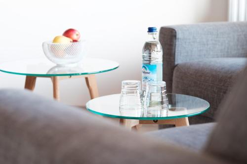 a bottle of water and glasses on two tables at bichl 761 in Fischen