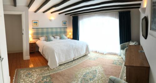 a bedroom with a bed and a large window at The Steadings Cottage in Chesters