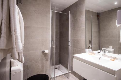 a bathroom with a shower and a sink and a toilet at La Résidence in Lyon