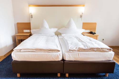 two beds with pillows on top of them in a room at Romantik Hotel Aquarium in Friedrichstadt