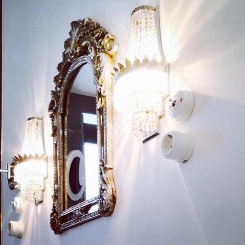 a mirror on a wall with two lights and a lightswitch at Purple Dog Suites in León