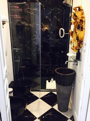 a black and white bathroom with a shower and a toilet at Purple Dog Suites in León
