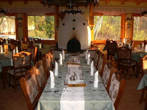 une salle à manger avec une grande table et des chaises dans l'établissement Forster Vadászkastély és Szálloda, à Bugyi