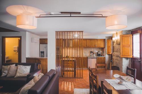a living room and kitchen with a table and a couch at Casa da Obrinha in Bouro