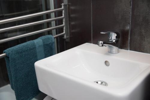 ティミショアラにあるUltracentral, brand new, modern and cozy apartmentのバスルーム(白いシンク、青いタオル付)