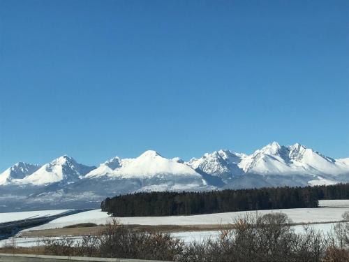 a mountain range with snow covered mountains in the background at Chata Eden in Hrabušice