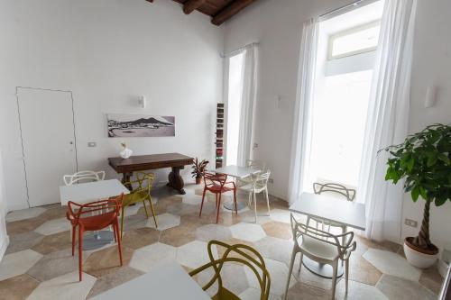 ナポリにあるSavoy Rivieraの椅子とテーブル、テーブルとデスクが備わる客室です。