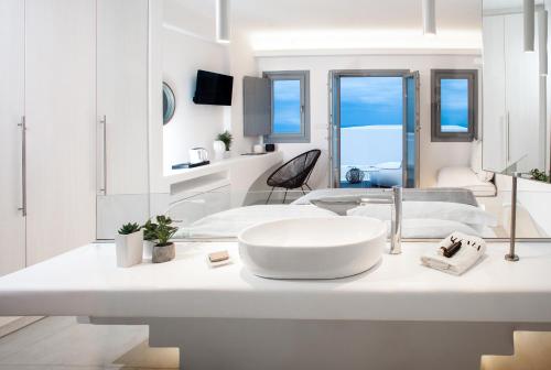 a white bathroom with a sink and a mirror at Alunia Incognito Suites - Adults Only in Pirgos