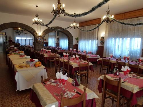 un comedor con mesas, sillas y lámparas de araña en Albergo Ristorante Poli, en Madonna di Fornelli