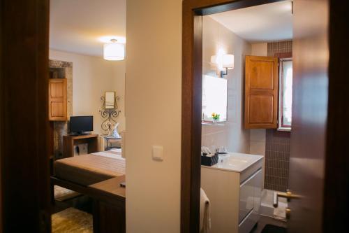 a small bathroom with a sink and a mirror at Casa da Obrinha in Bouro