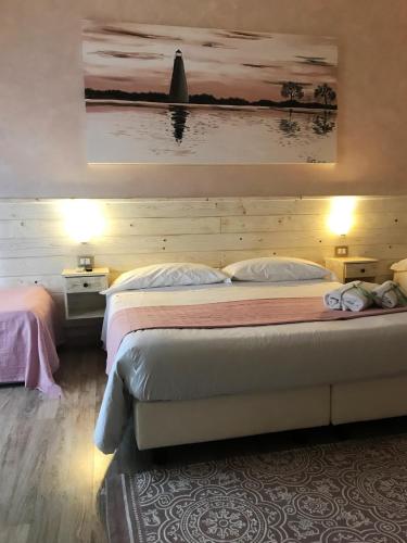 a bedroom with two beds and a painting on the wall at Fiumicino Airport B&B Deluxe in Fiumicino