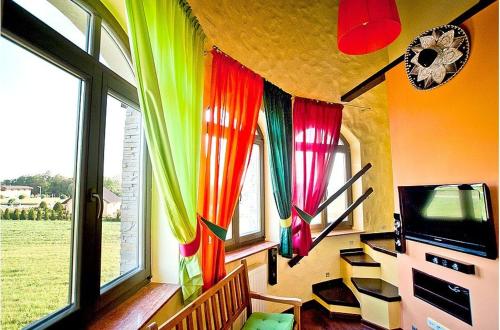 a living room with colorful curtains and a tv at Pensjonat Kolory Świata in Solec-Zdrój