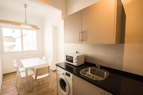 a kitchen with a sink and a microwave and a table at 1977 in Faro