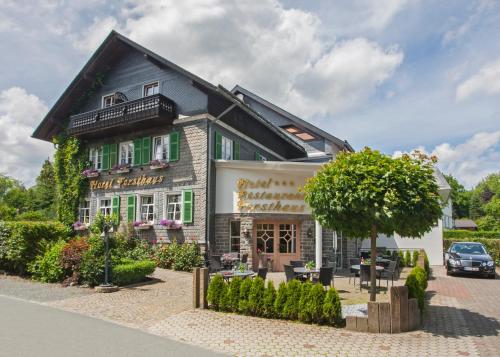 a building with a tree in front of it at Hotel Forsthaus in Winterberg