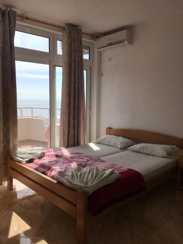 a bedroom with a bed and a large window at Sand and Sea Apartments in Ulcinj