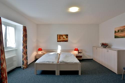a bedroom with a bed and two night stands at Hôtel du Port - Free Parking - Breakfast included in Estavayer-le-Lac