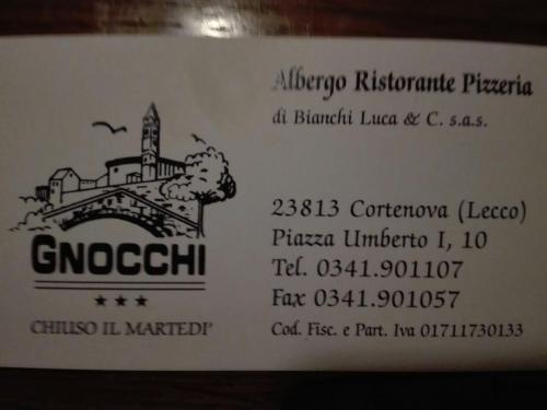 una señal blanca con una foto de un puente en Albergo ristorante Gnocchi en Cortenova