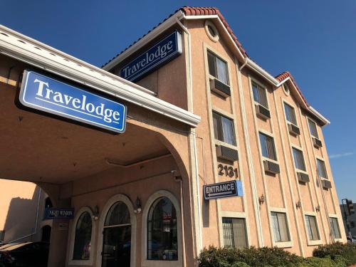 a large building with a sign on the side of it at Travelodge by Wyndham Pasadena Central in Pasadena